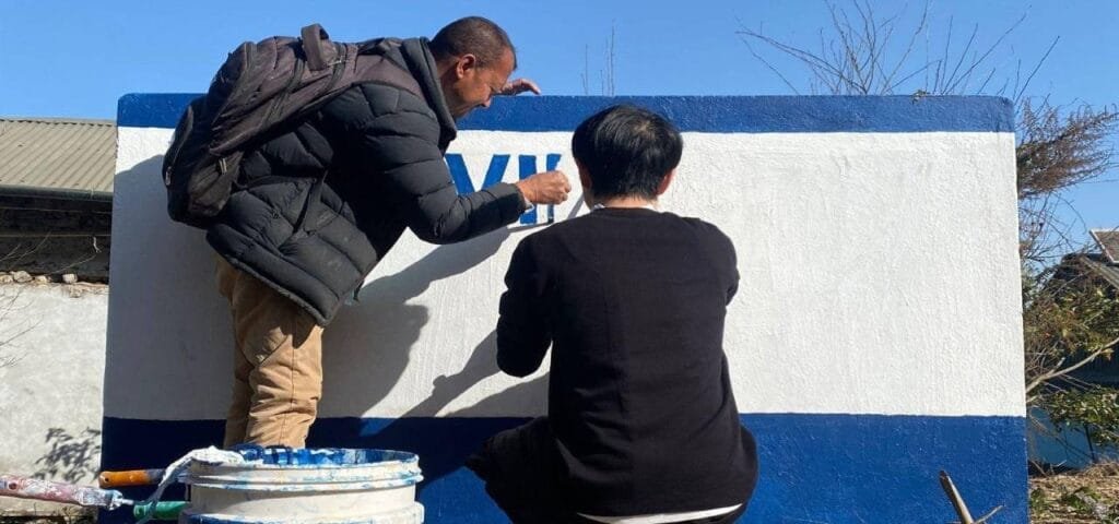 volunteers paint water tanks